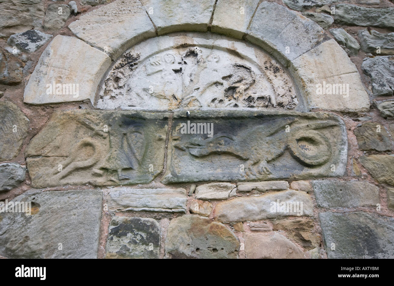 St John the Baptist Church in Ault Hucknall showing stone carving of St George and the Dragon, seperated by a cross. Stock Photo