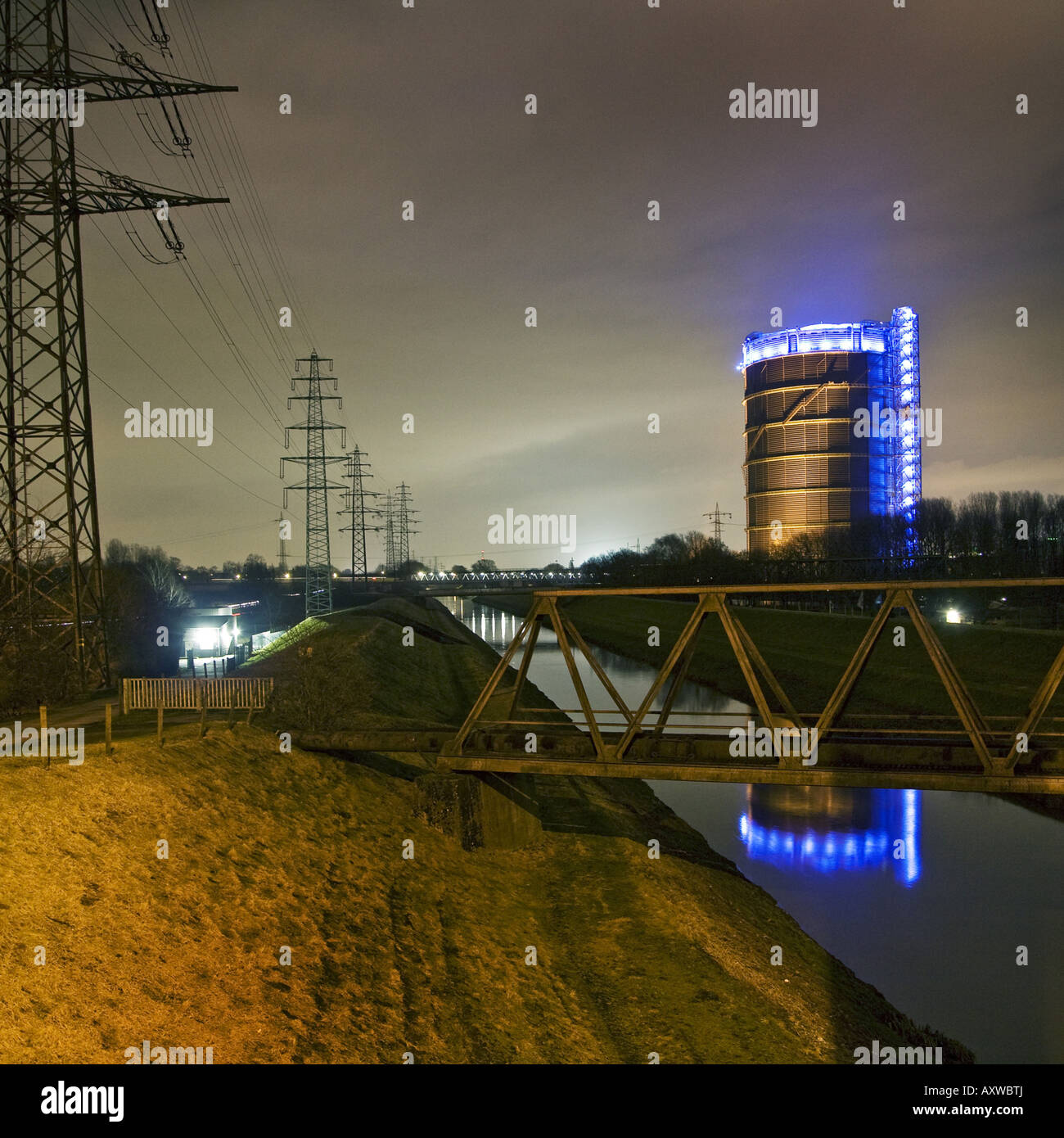 Emscher River with the spectacular illuminated Gasometer at night, Germany, North Rhine-Westphalia, Ruhr Area, Oberhausen Stock Photo