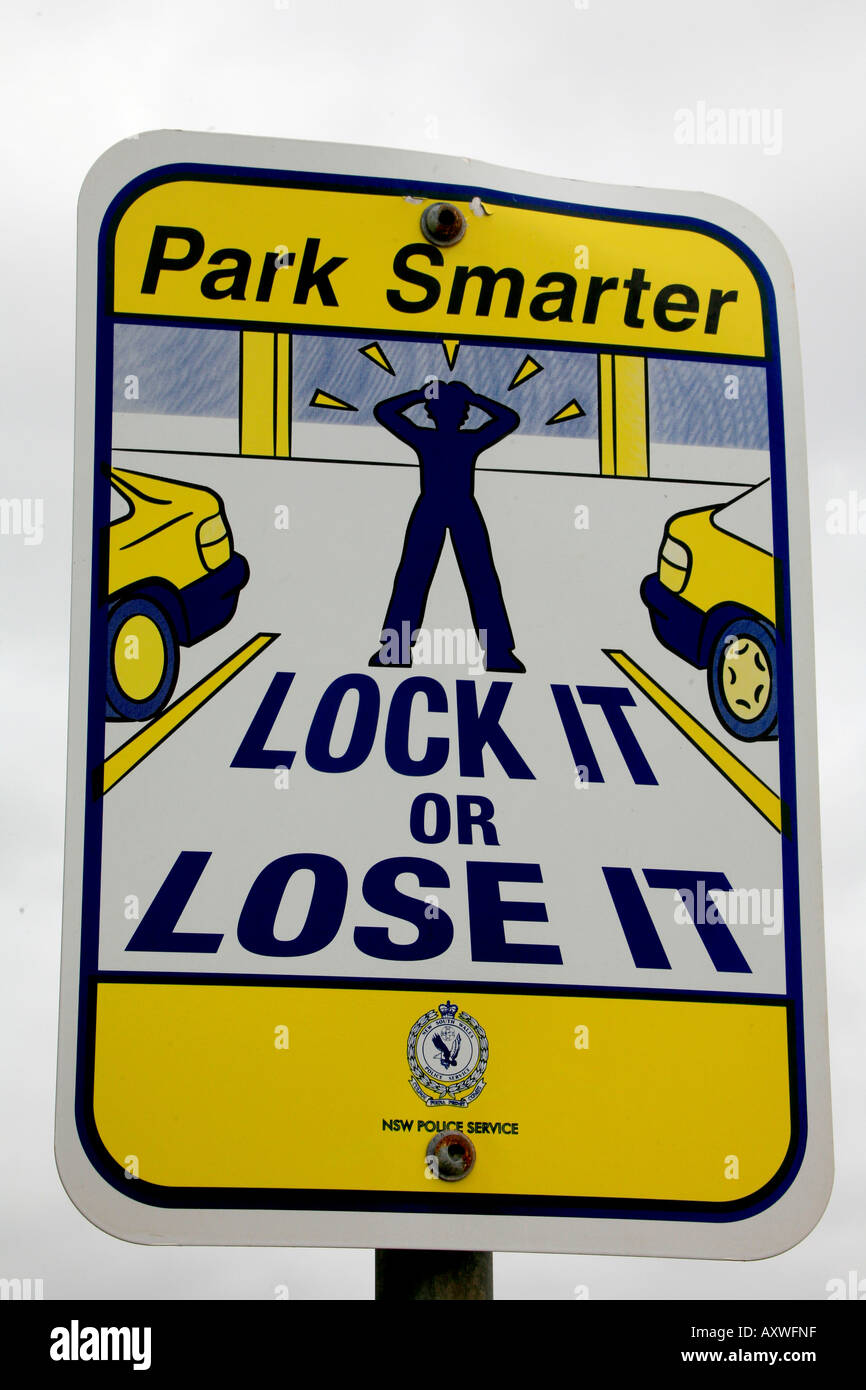 A sign warns drivers to lock their cars at an Australian beachside parking lot Stock Photo