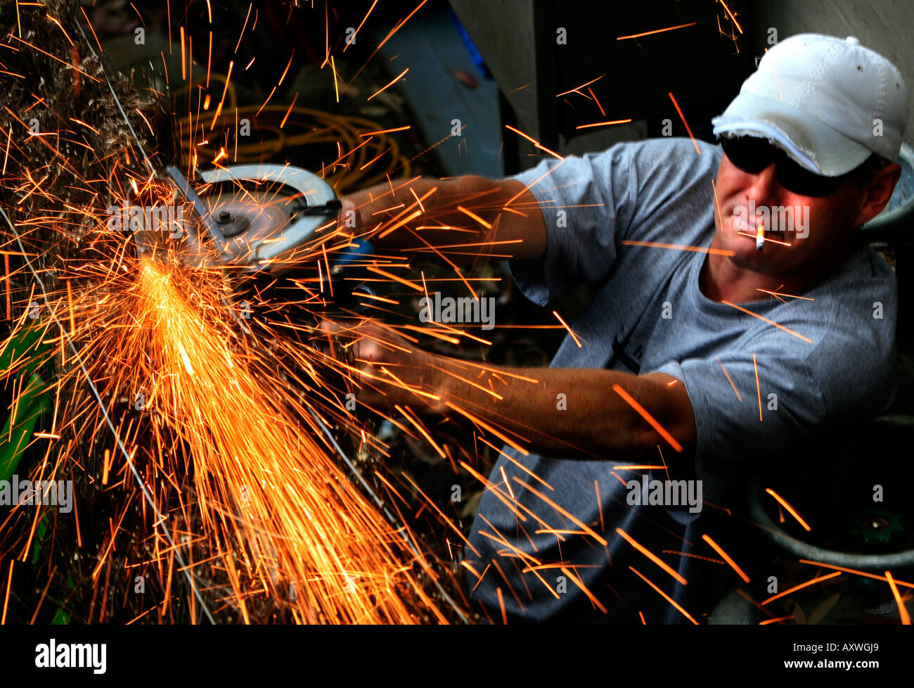 A worker uses a grinder with sparks flying off it Stock Photo 9670952