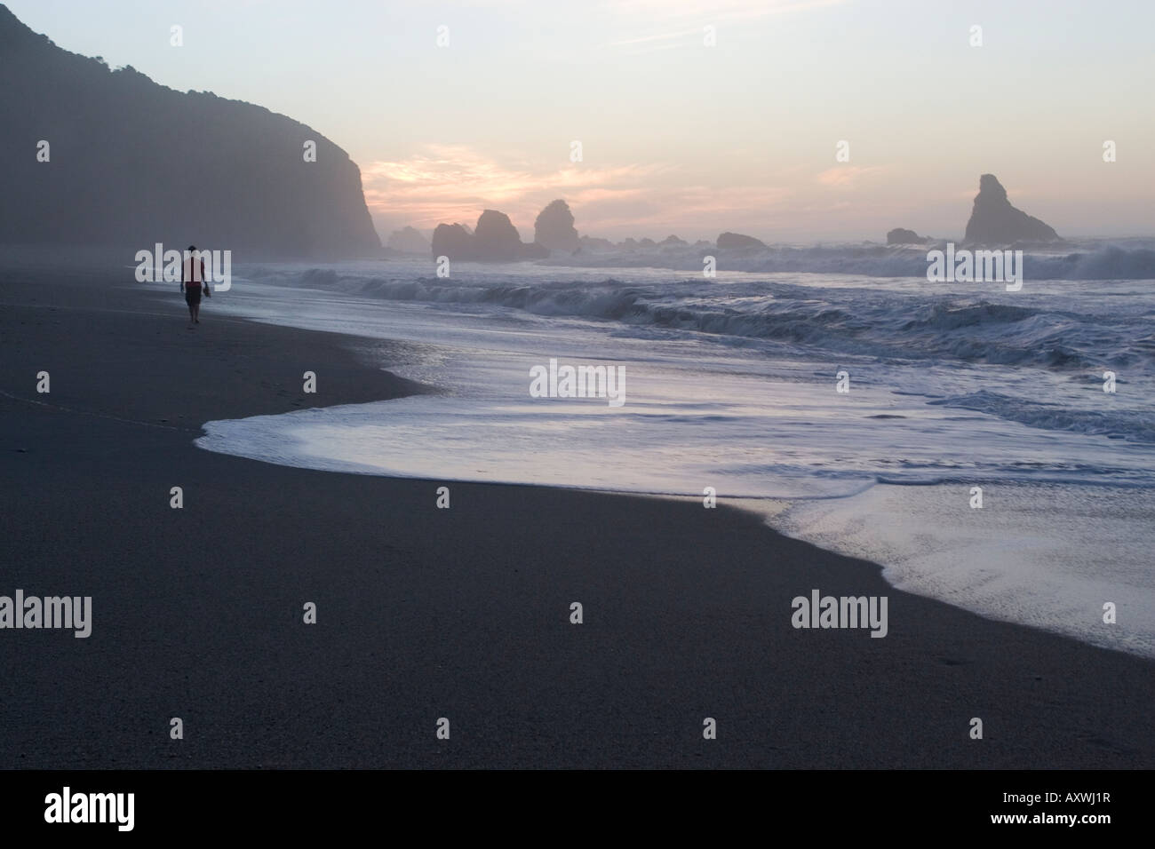Silhouette Walking Along Beach at Sunset Stock Photo - Alamy
