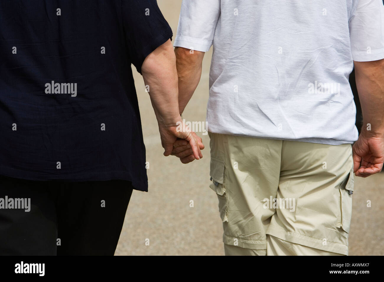 Elderly couple walking while holding hands Stock Photo Alamy