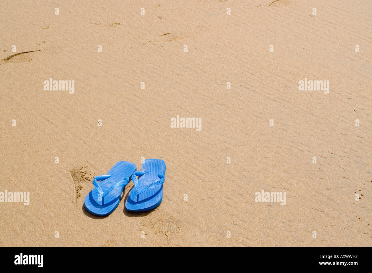 Blue Flip flops on sandy beach Stock Photo - Alamy