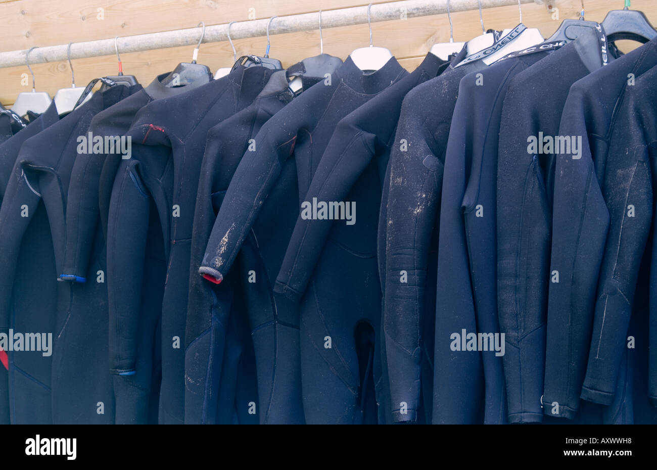 Wetsuits hanging out to dry outside surf school, Newquay, Cornwall