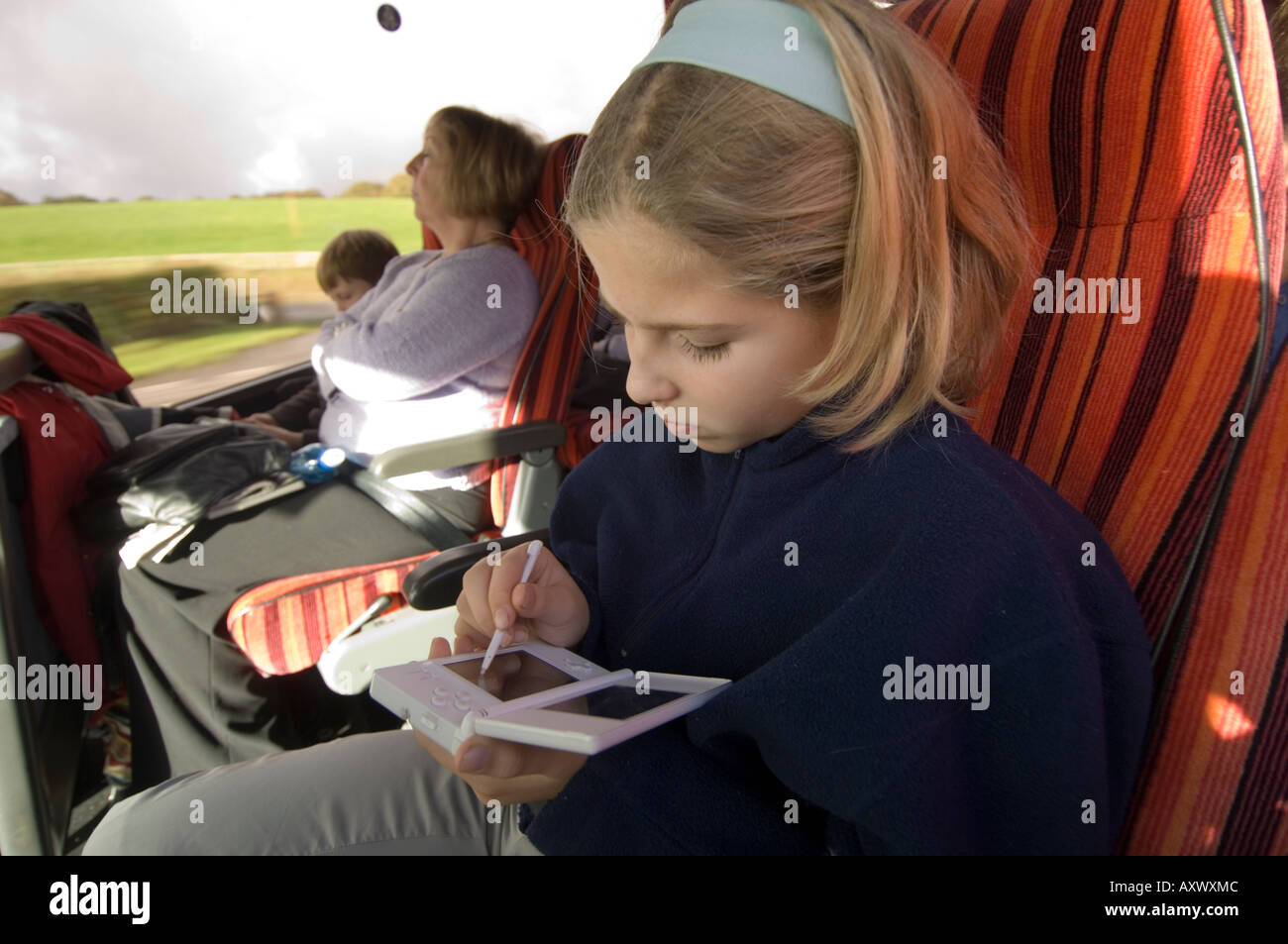 Twelve year old girl playing on her Nintendo DS computer game console