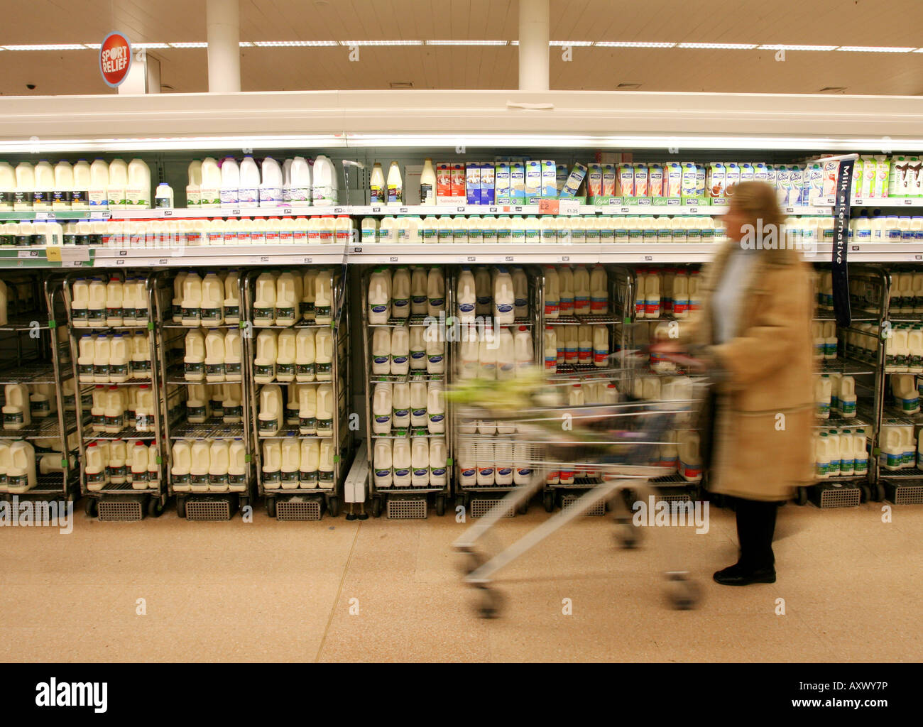 A shopper picks milk off the shelf at Sainsburys supermarket at London