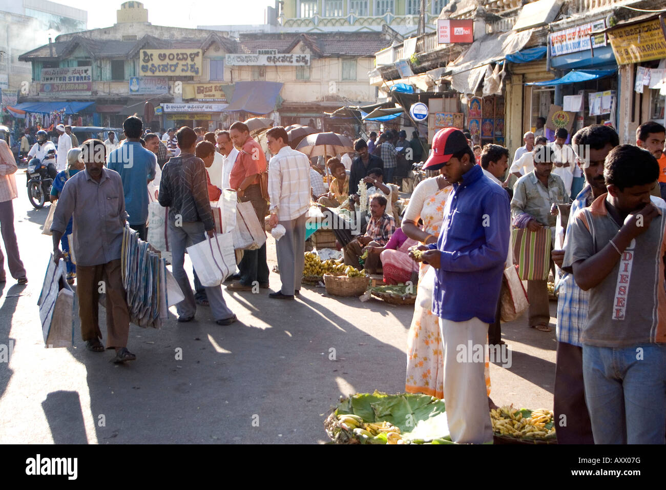 A street scene from central Mysore near to the city's Devaraja Urs Market. People trade flowers and other goods to bypassers. Stock Photo
