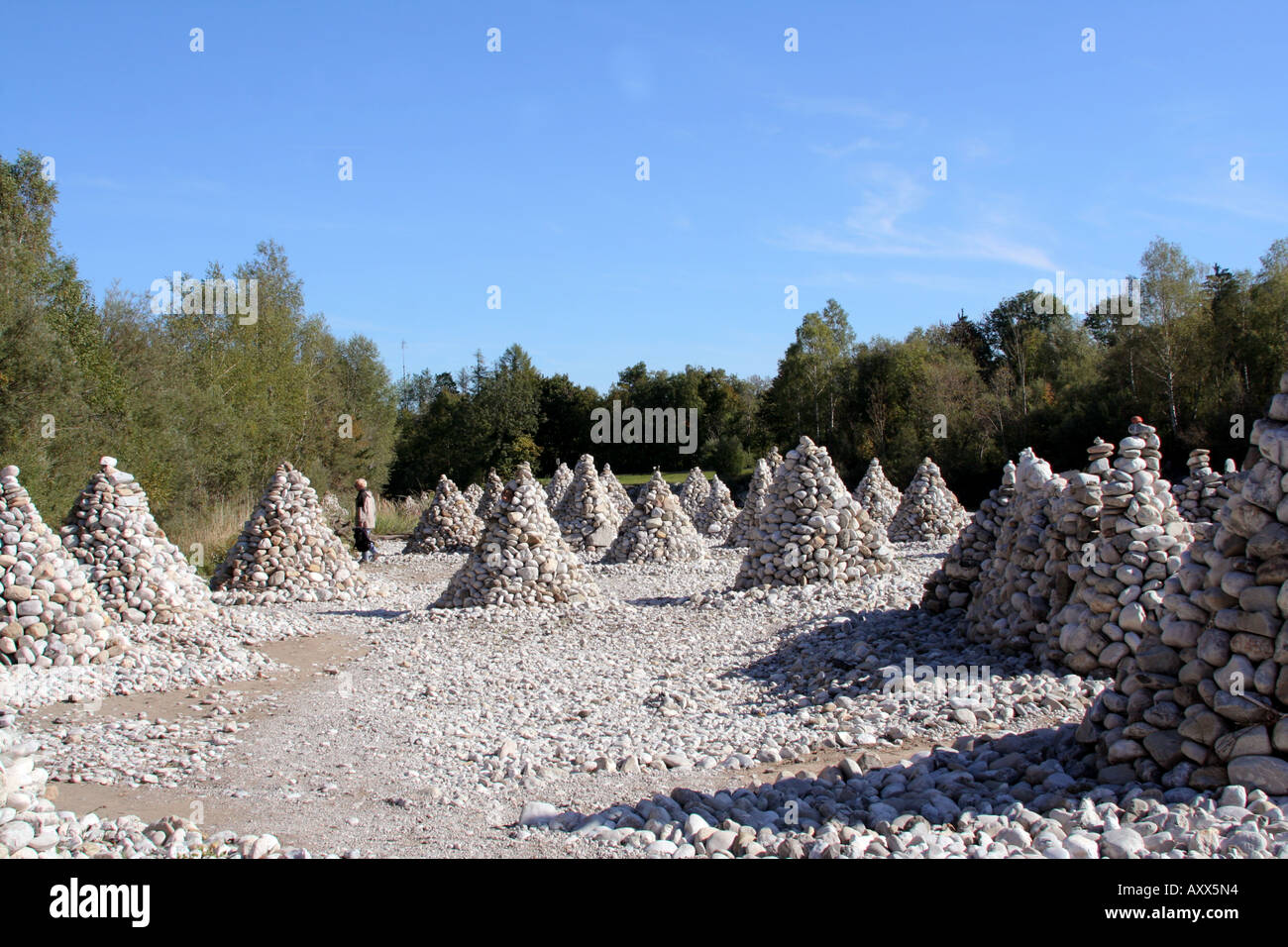 Stone Pyramids along the River Isar between Bad Toelz and Lenggries person in the background Bavaria Germany Stock Photo