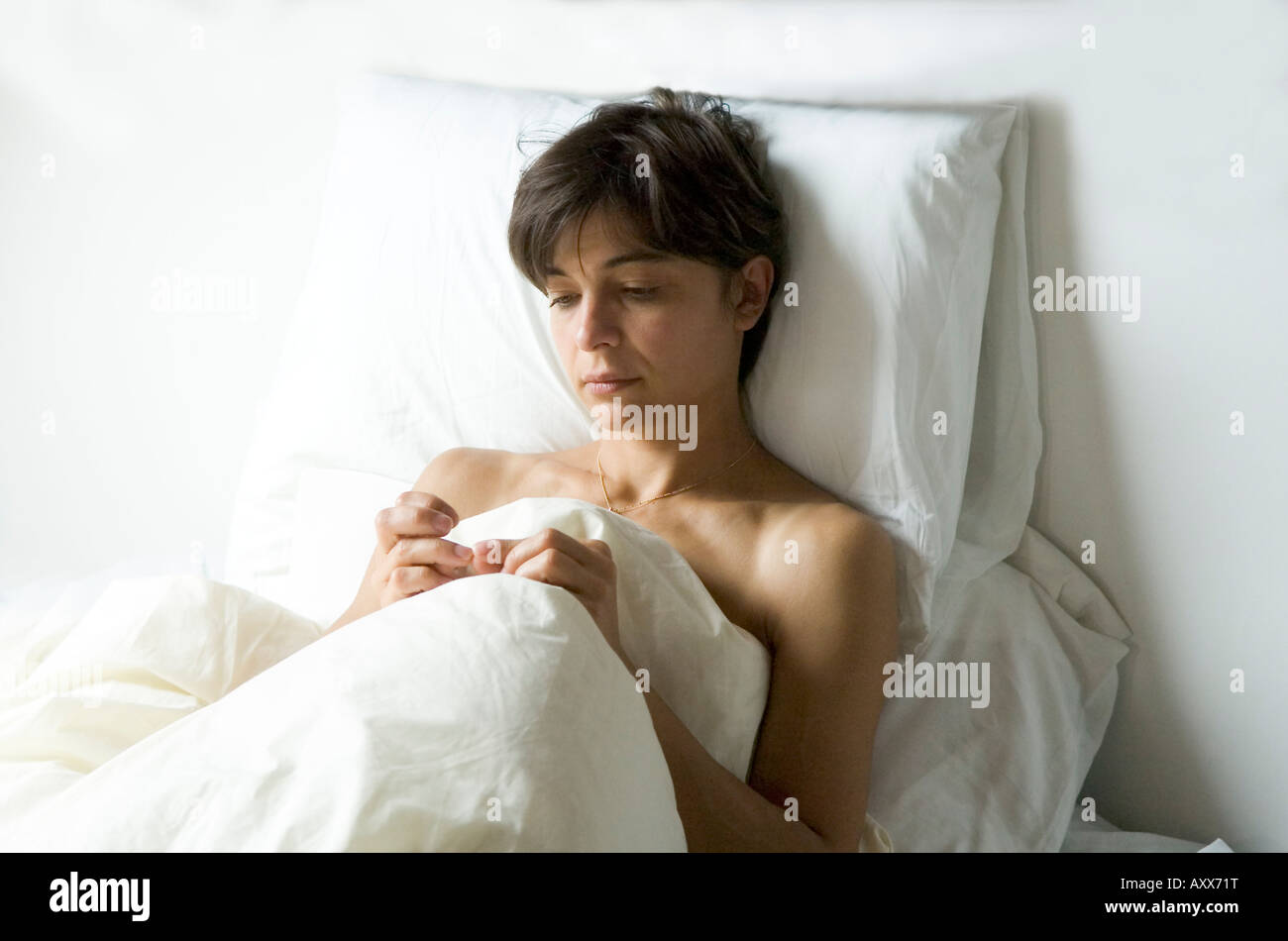 Upon waking a young Belarussian woman immigrant is sad and thoughtful about her future life in Great Britain Stock Photo