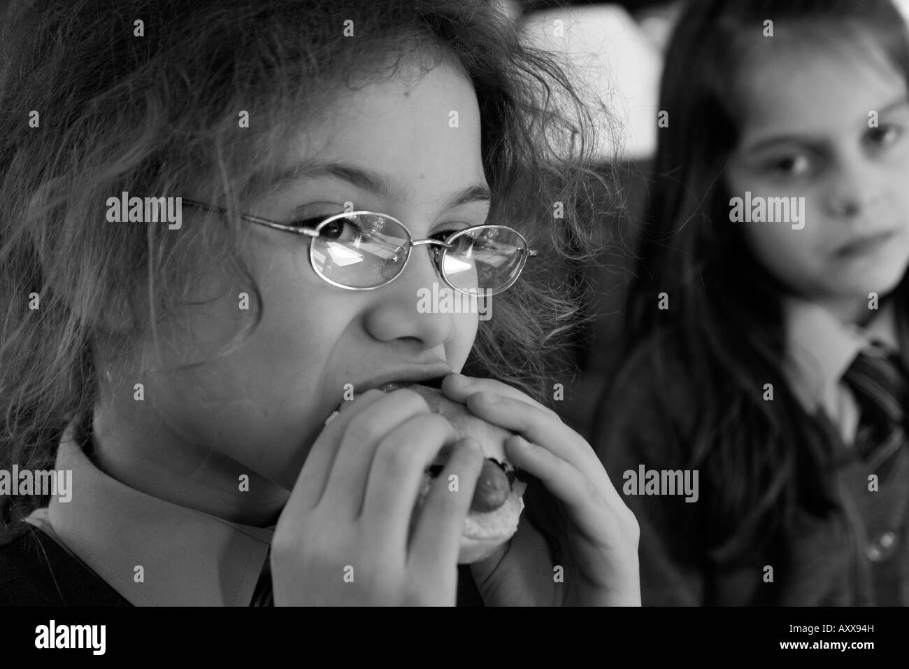 preteen girl eating hotdog Stock Photo