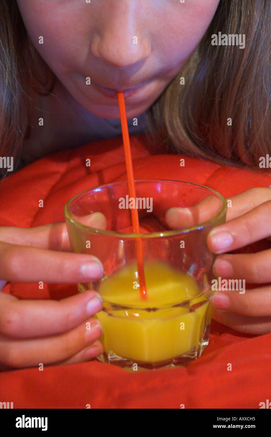young girl drinking orange juice with red straw Stock Photo Alamy