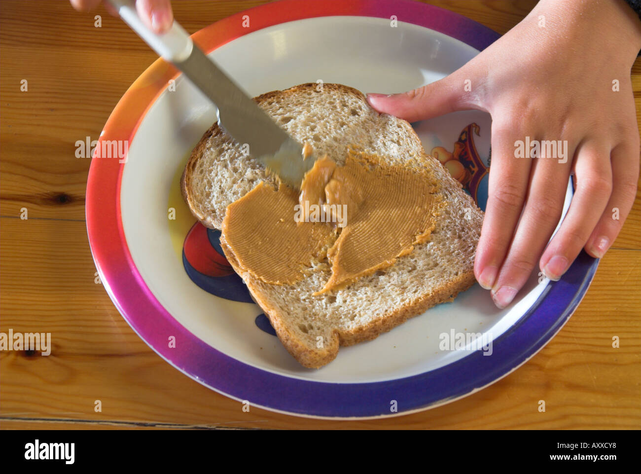 spreading peanut butter on slice of bread Stock Photo Alamy