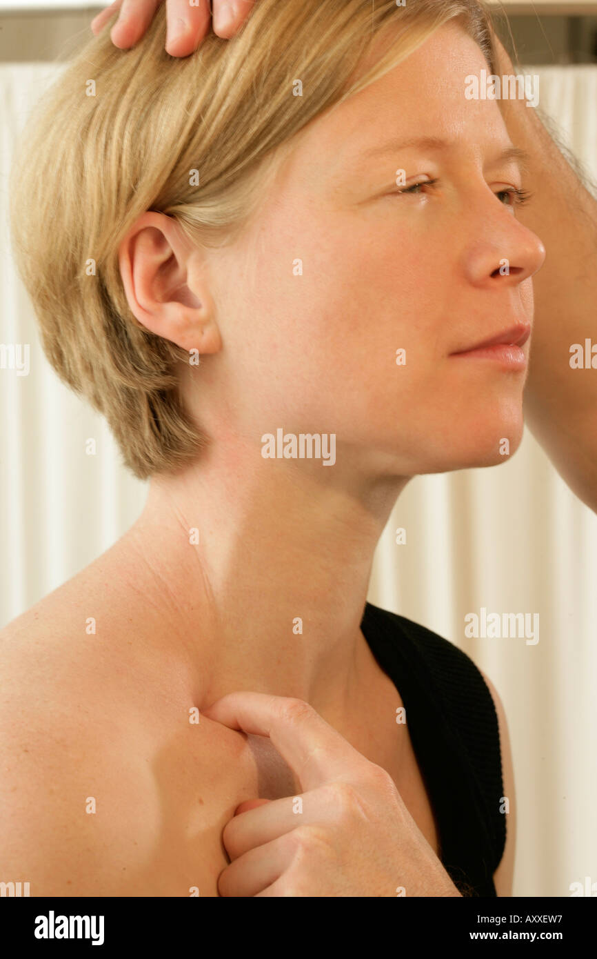 Masseuse points and presses on woman's clavicle or collarbone. Using classic western massage techniques. Stock Photo
