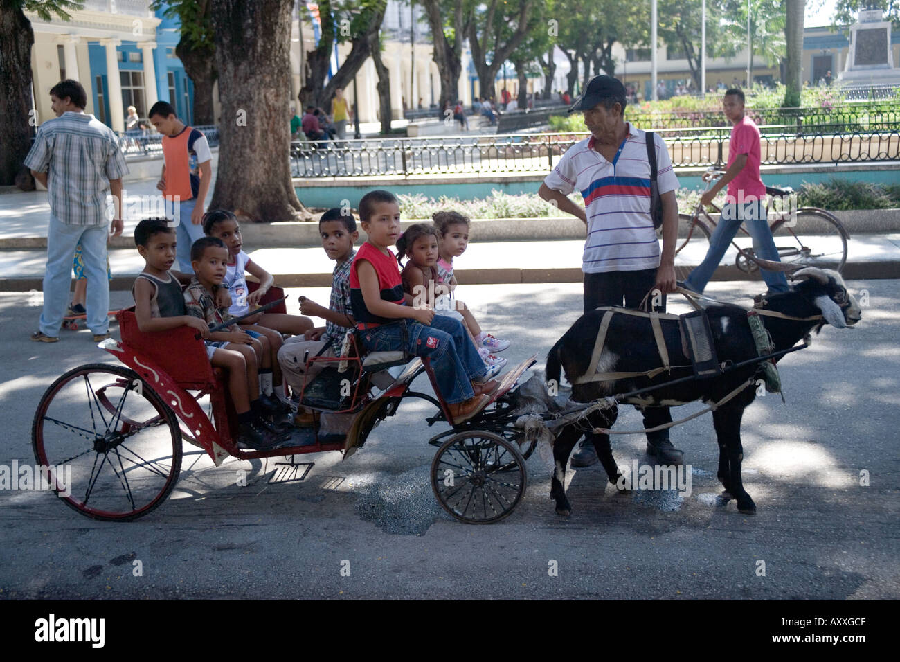 Children being drawn in a cart pulled by a goat in the main square the Parque Cespedes of Bayamo,Cuba Stock Photo