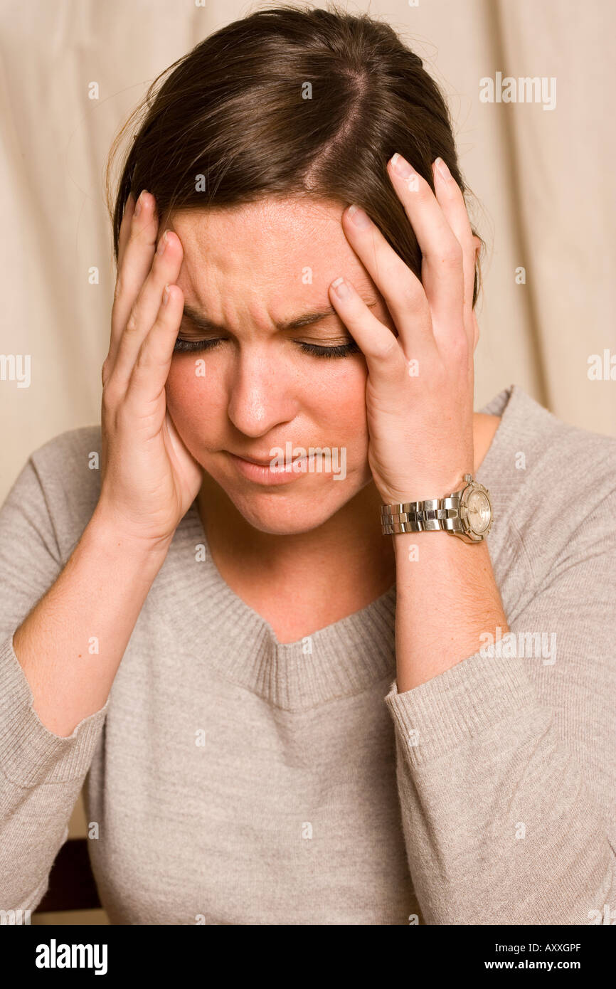 Young woman experiencing a headache, possibly a migraine. Stock Photo