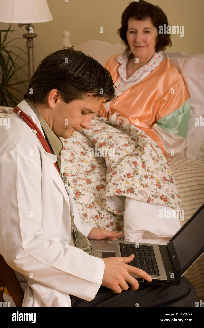 Healthcare worker uses computer technology to update patient record ...