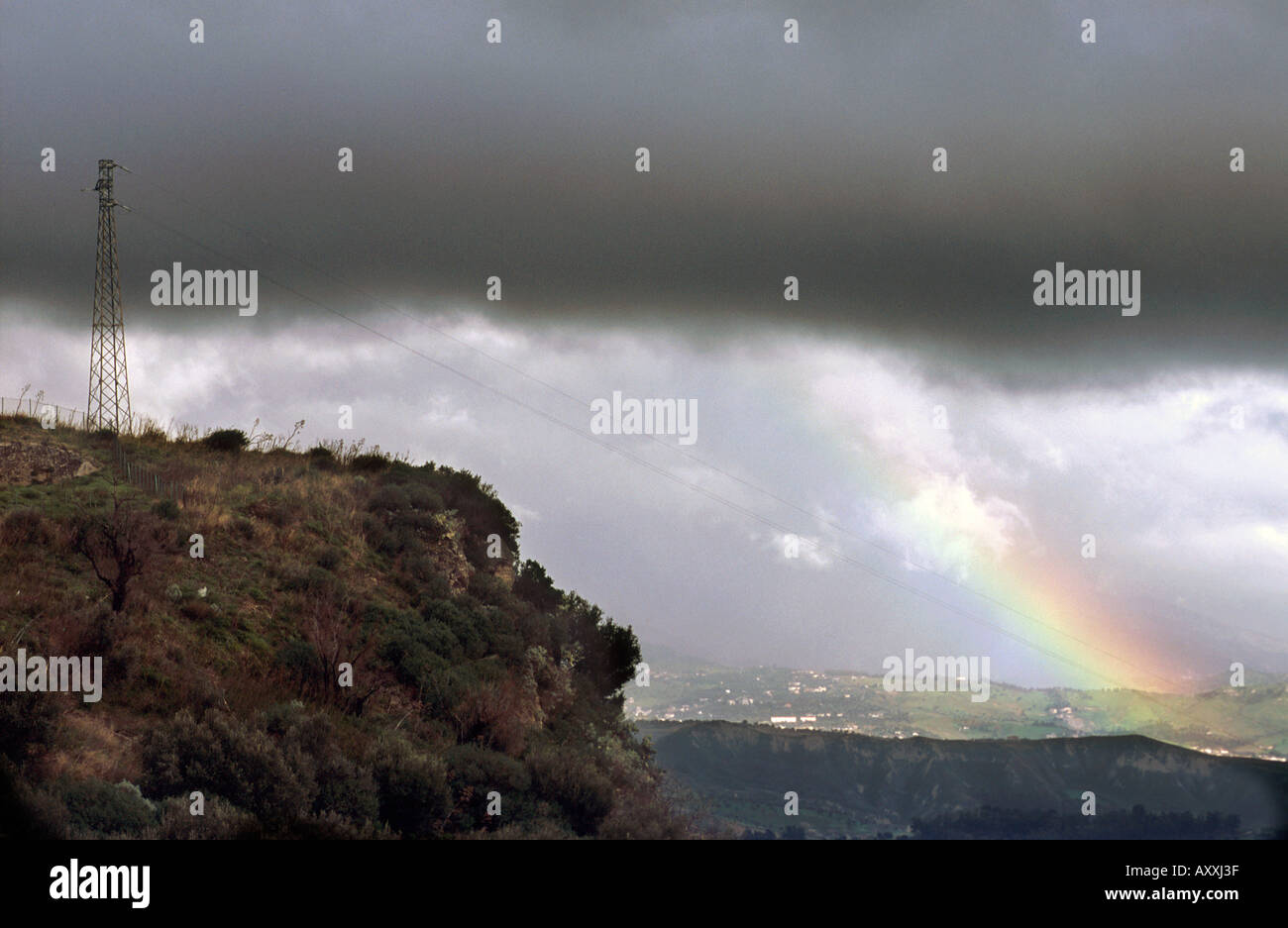 Electricity Pylon against cloudy sky and rainbow Stock Photo - Alamy