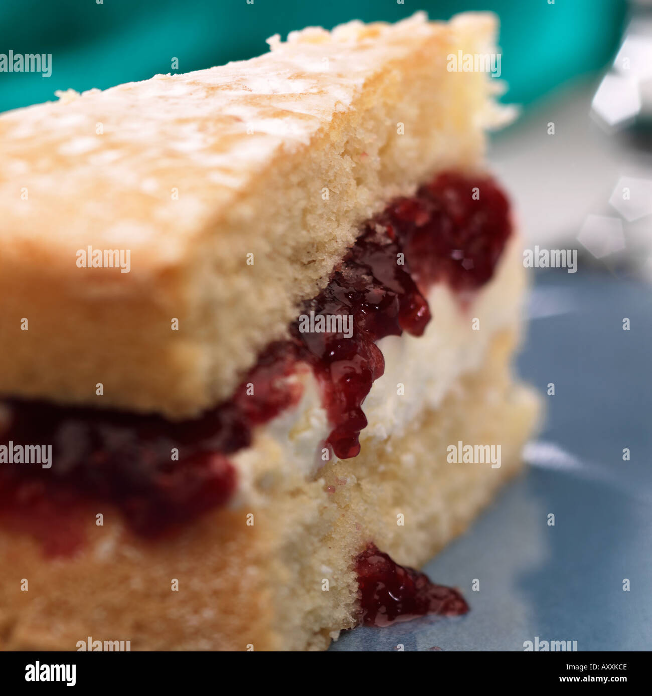 Slice of sponge cake with jam & buttercream filling oozing out Stock