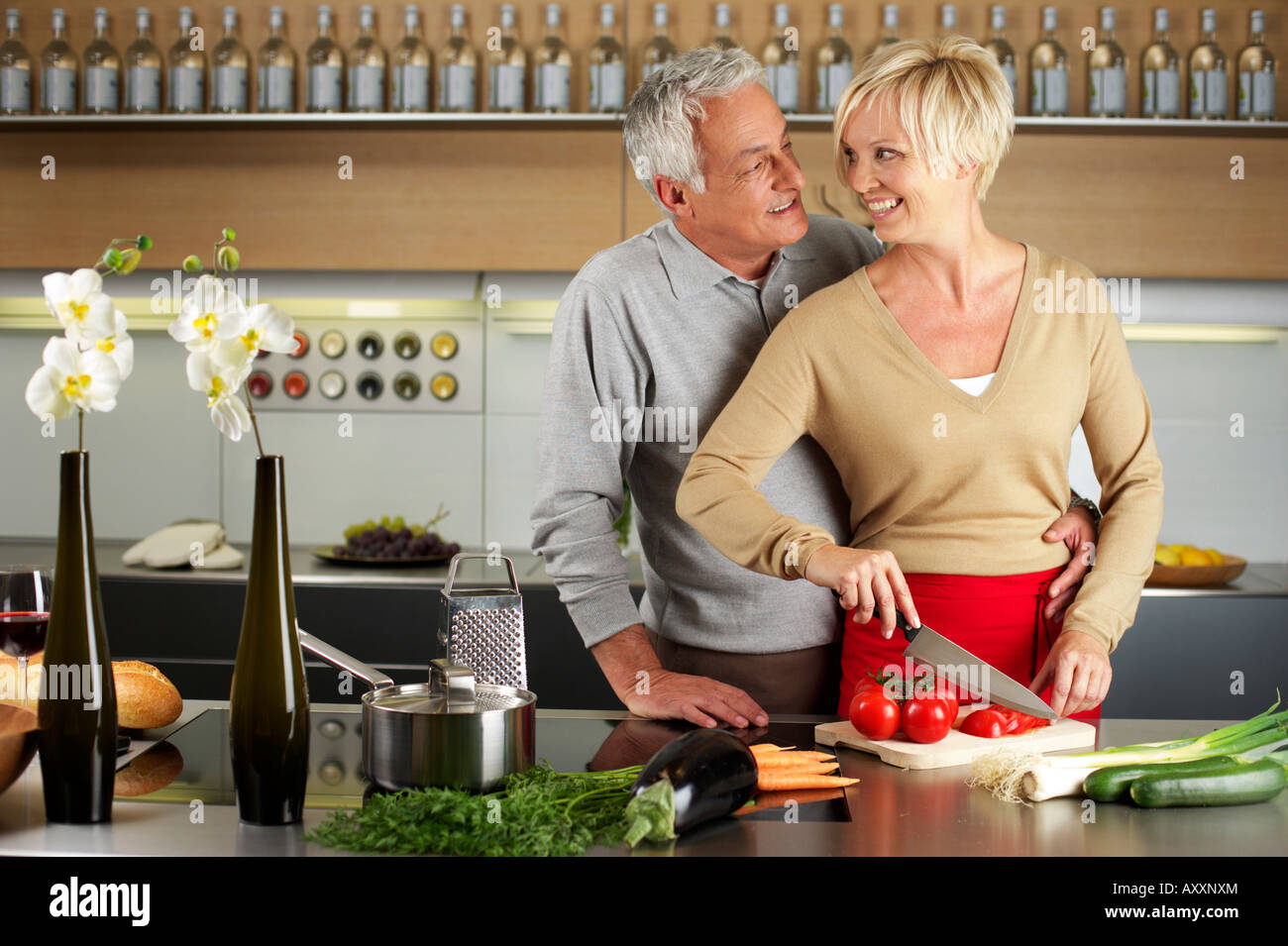 Blond woman and gray-haired man cooking together Stock Photo