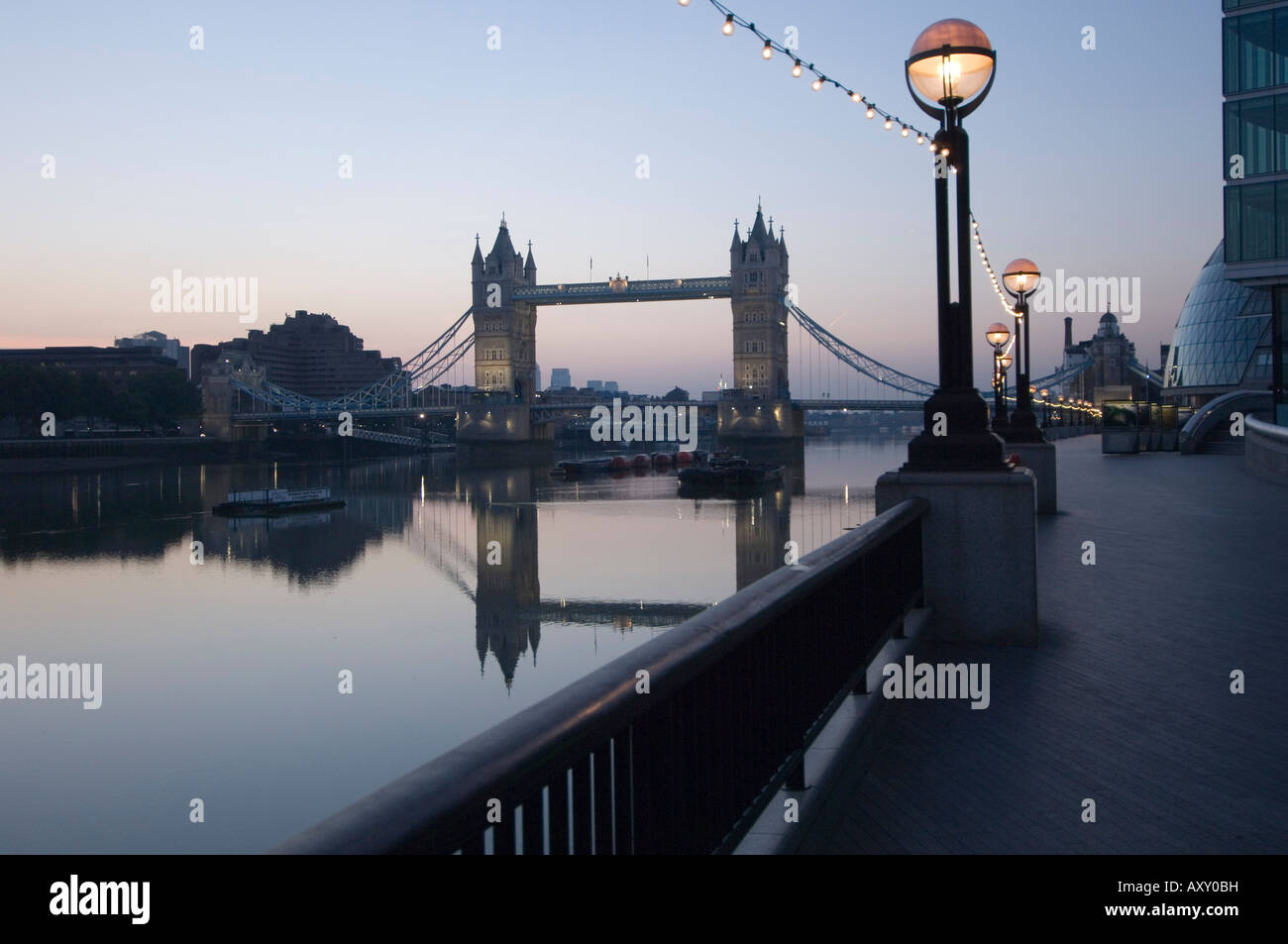 Tower Bridge reflected in the calm water of the River Thames in the early morning, London, England, UK Stock Photo