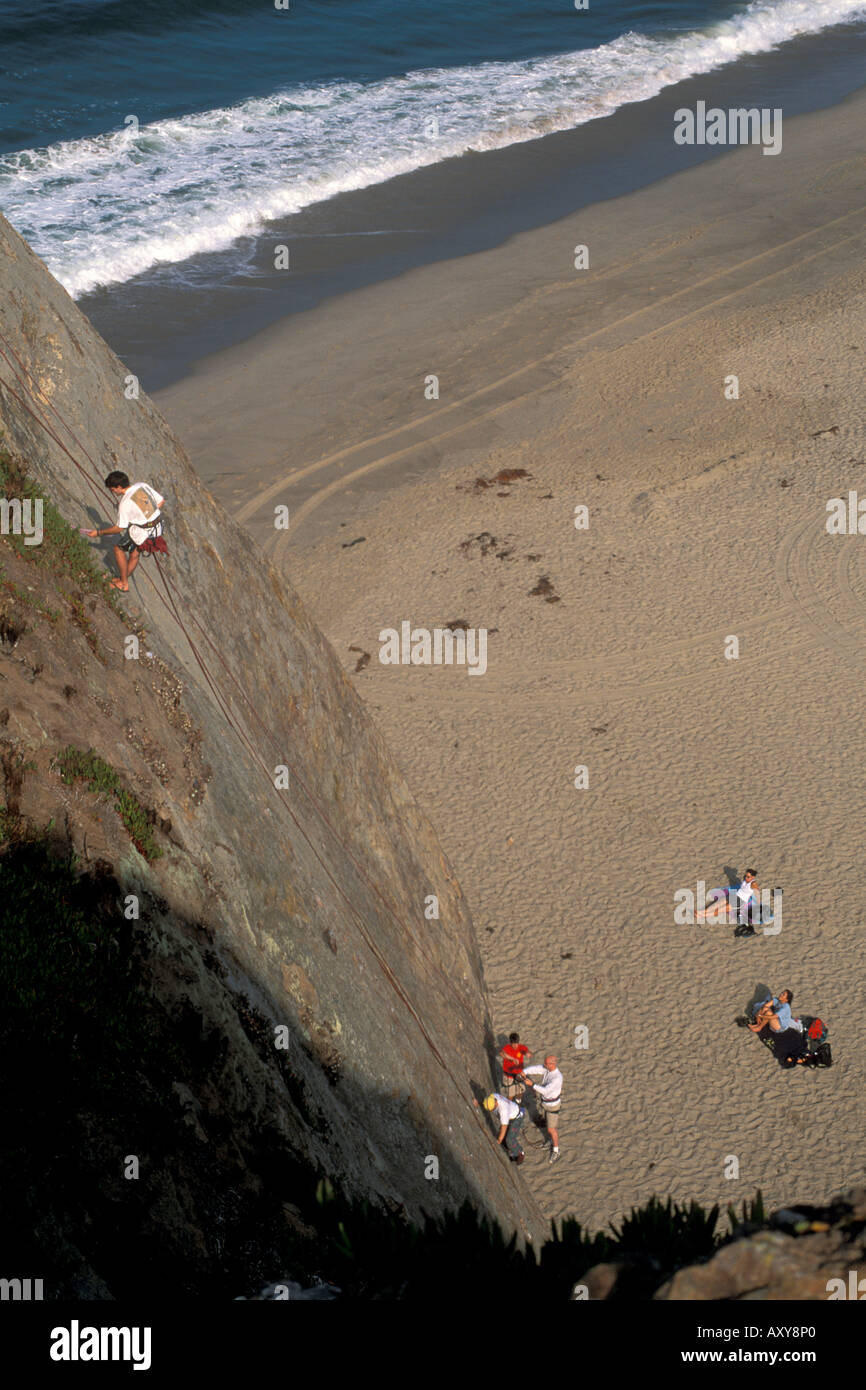 Rock climber rappelling down cliff after climb at Point Dume State Beach near Malibu Los Angeles