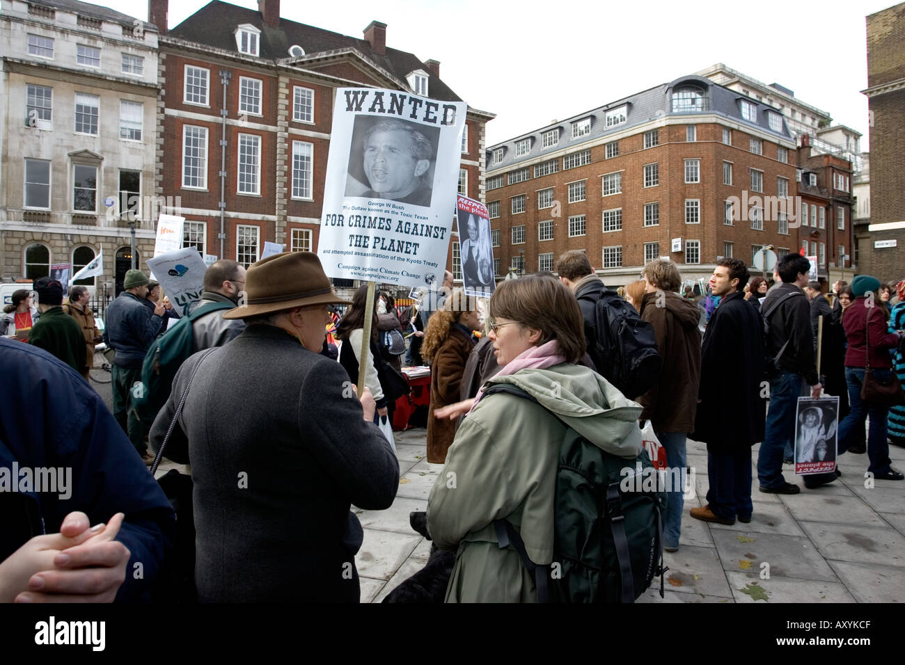 Campaigners with banner saying Wanted George Bush for Crimes against the Planet on Climate Change March on December 3 in London Stock Photo