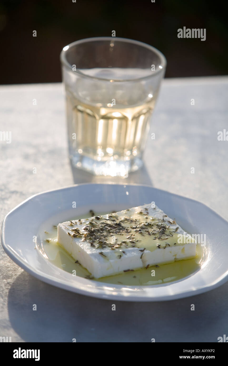 One small glass of traditional Greek Retsina white wine and a plate of  Greek tradtitional Feta cheese on marble table Stock Photo - Alamy