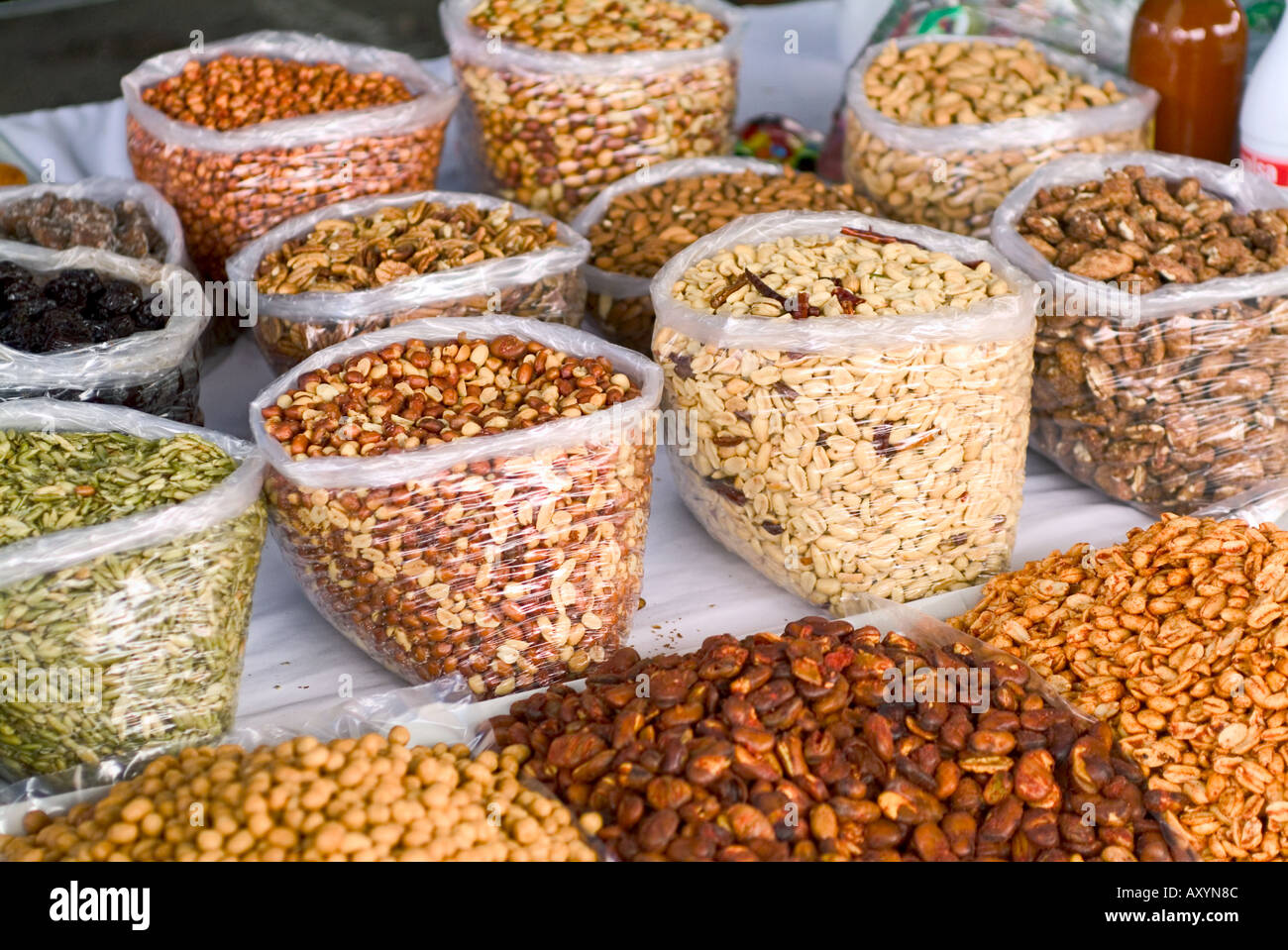 Bulk nuts and seeds in clear plastic bags at open air market Stock