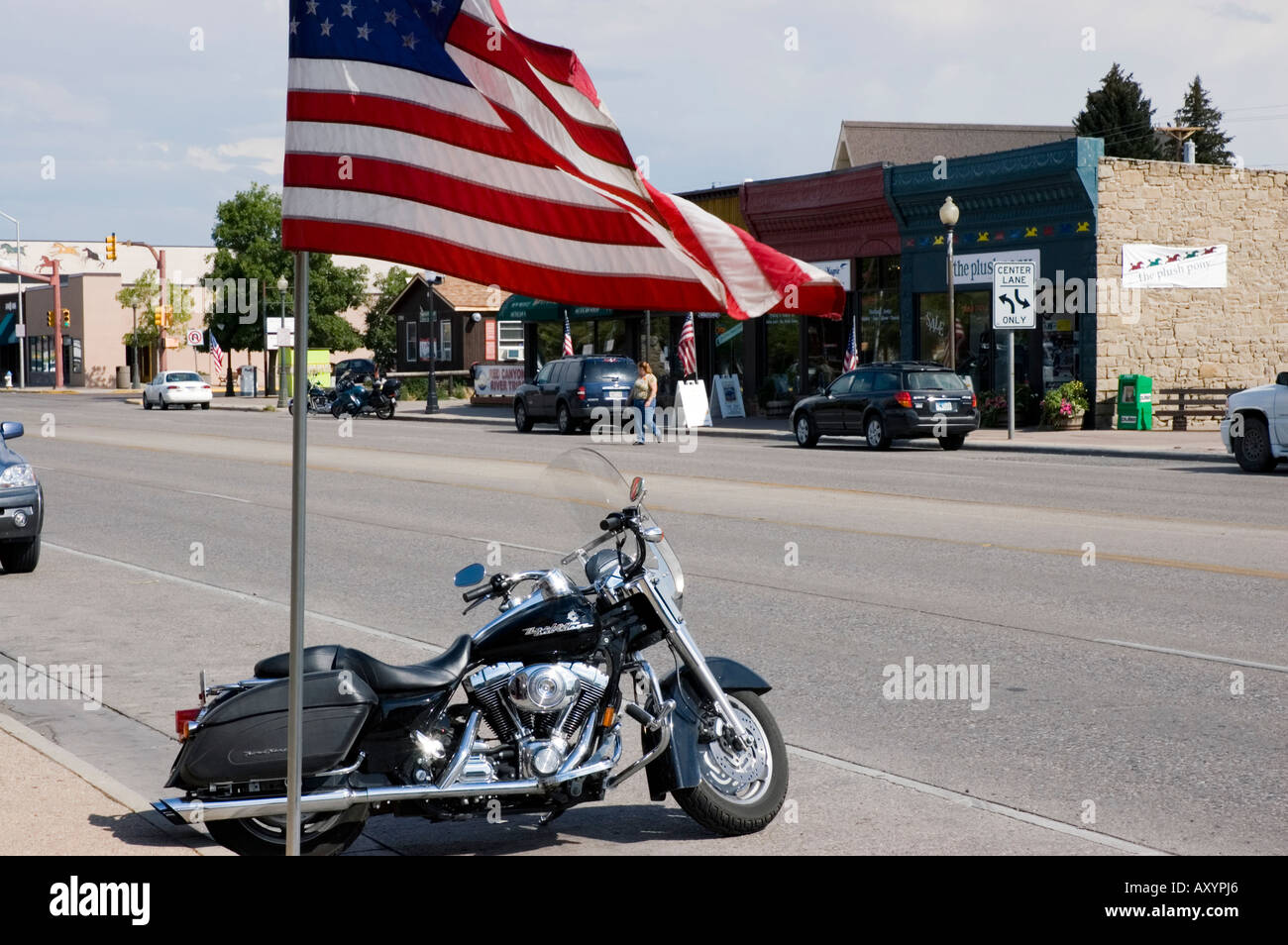 Harley Davidson motorcycle under Old Glory Small western town of Cody Park County Wyoming Western USA Stock Photo