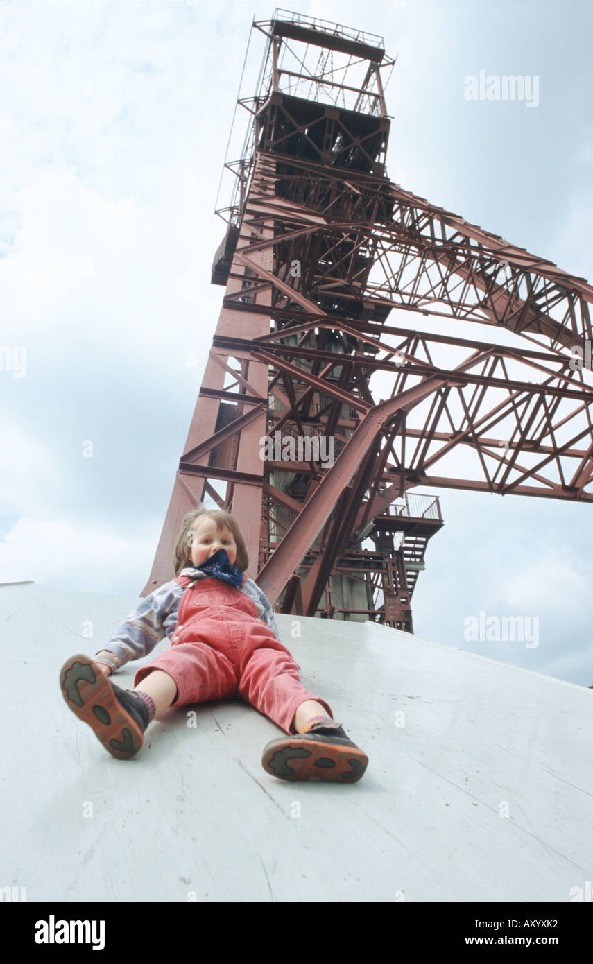 Child playing at the winding tower by the former coal mine Zollverein Schacht 3/7/10, Germany, North Rhine-Westphalia, Ruhr Are Stock Photo
