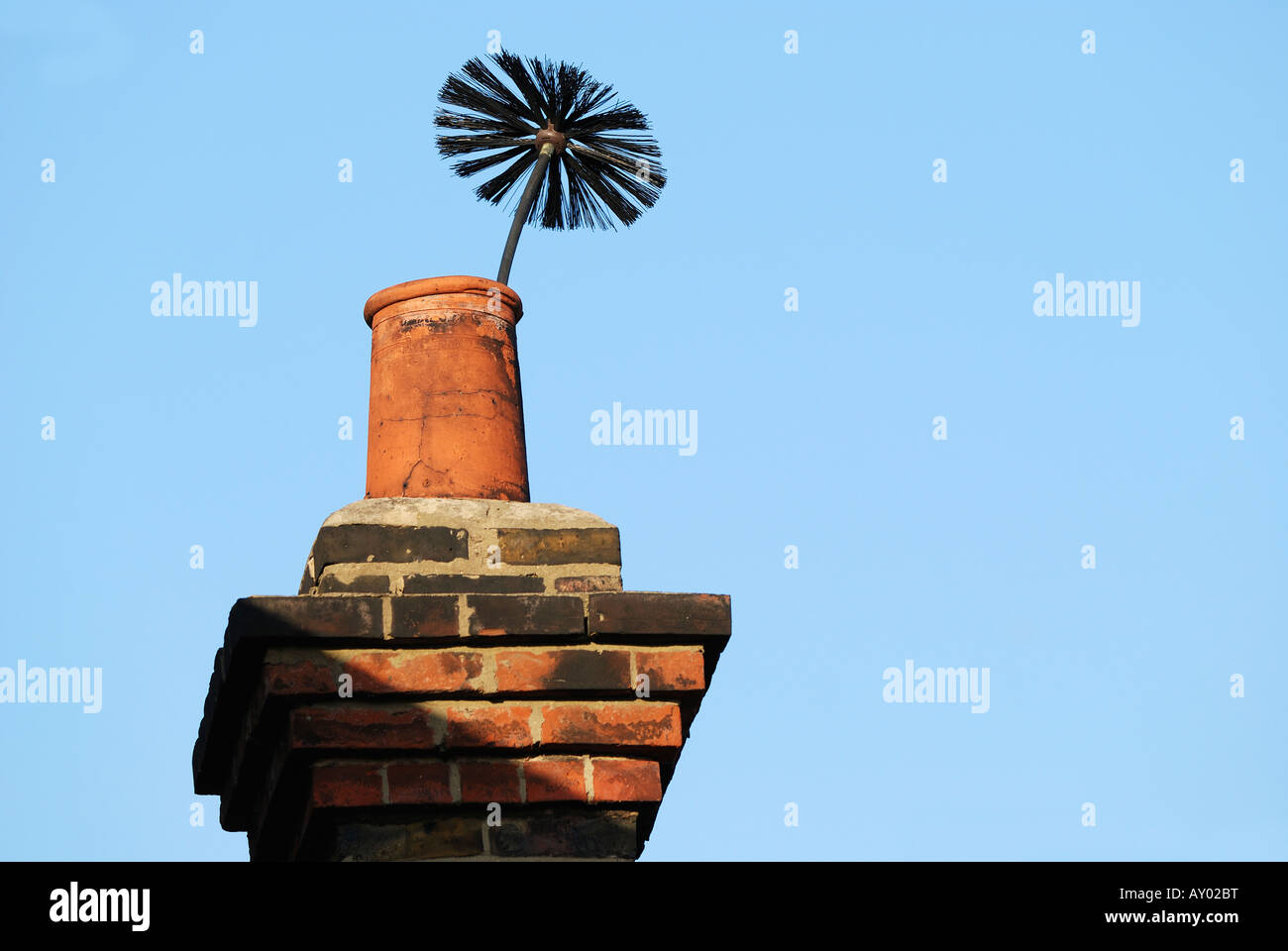 BUILDINGS WITH CHIMNEY SWEEPS BRUSH POKING OUT OF OLD CHIMNEY Stock Photo