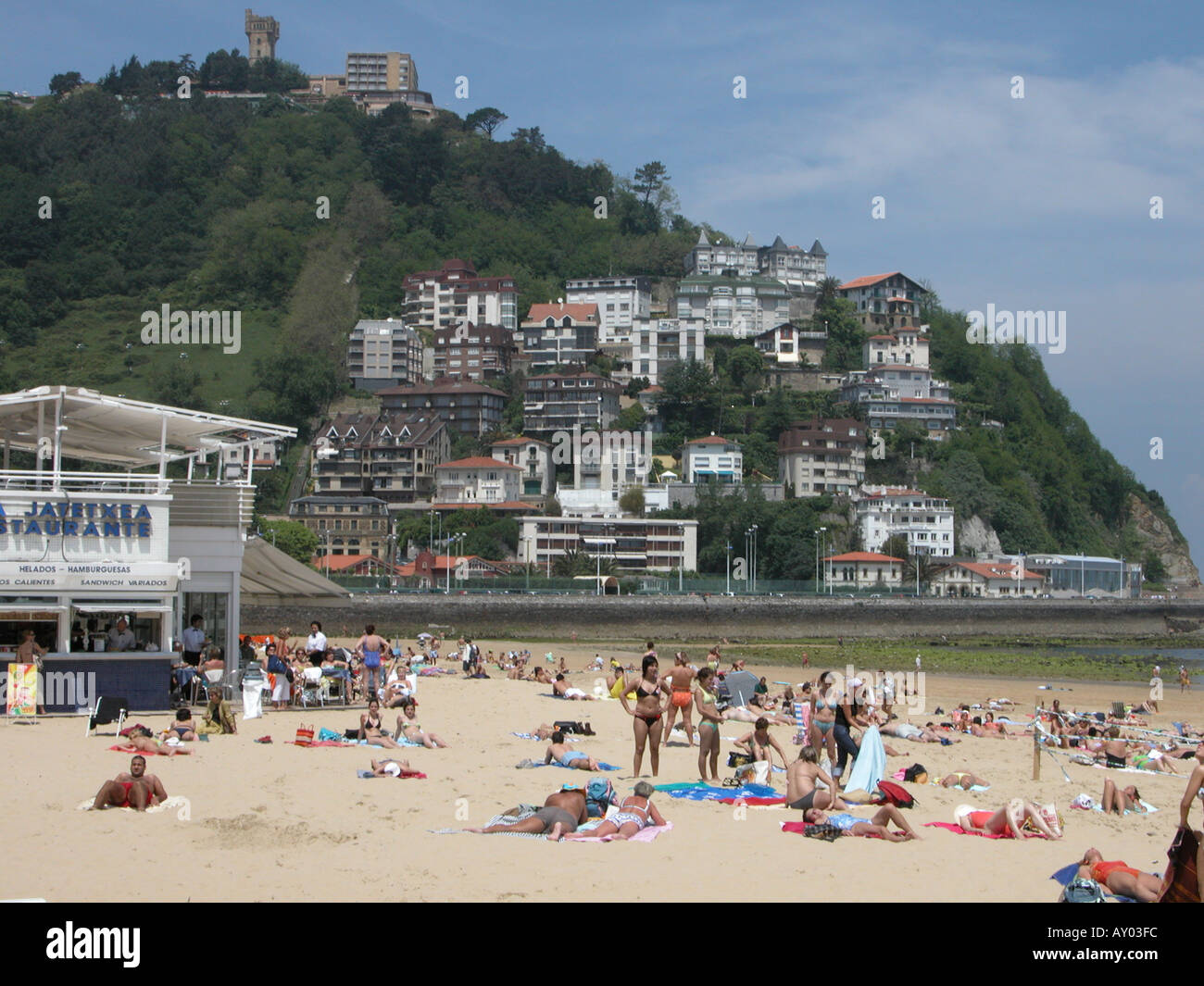 Sunbathers on Playa de Ondaretta beach and Mount Igueldo in San Sebastian Spain Stock Photo