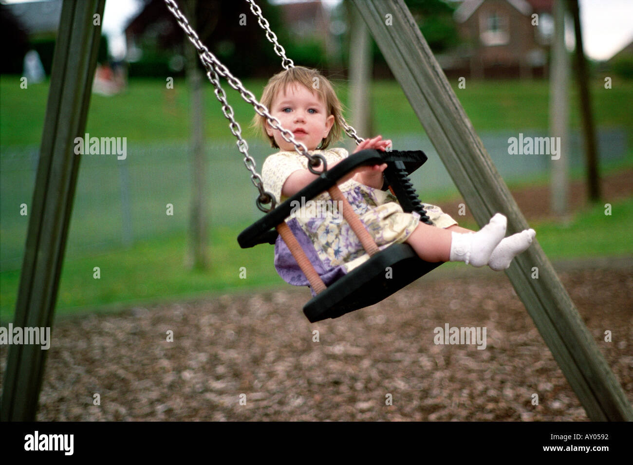 No worries a small girl enjoys a blissful swing  Stock Photo