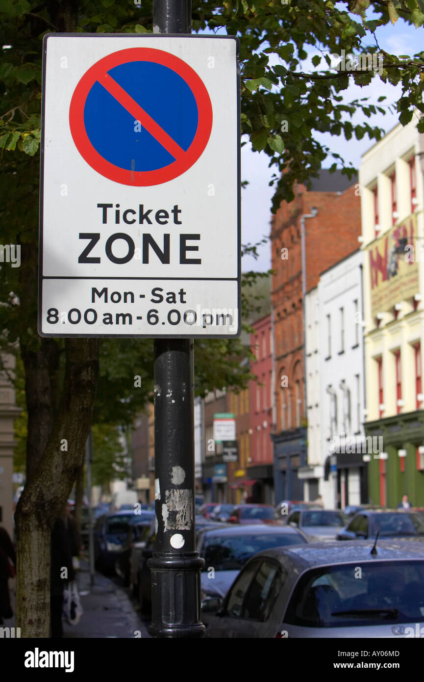 on street parking restriction area ticket zone sign monday to saturday 8am to 6pm on street with parked cars Stock Photo