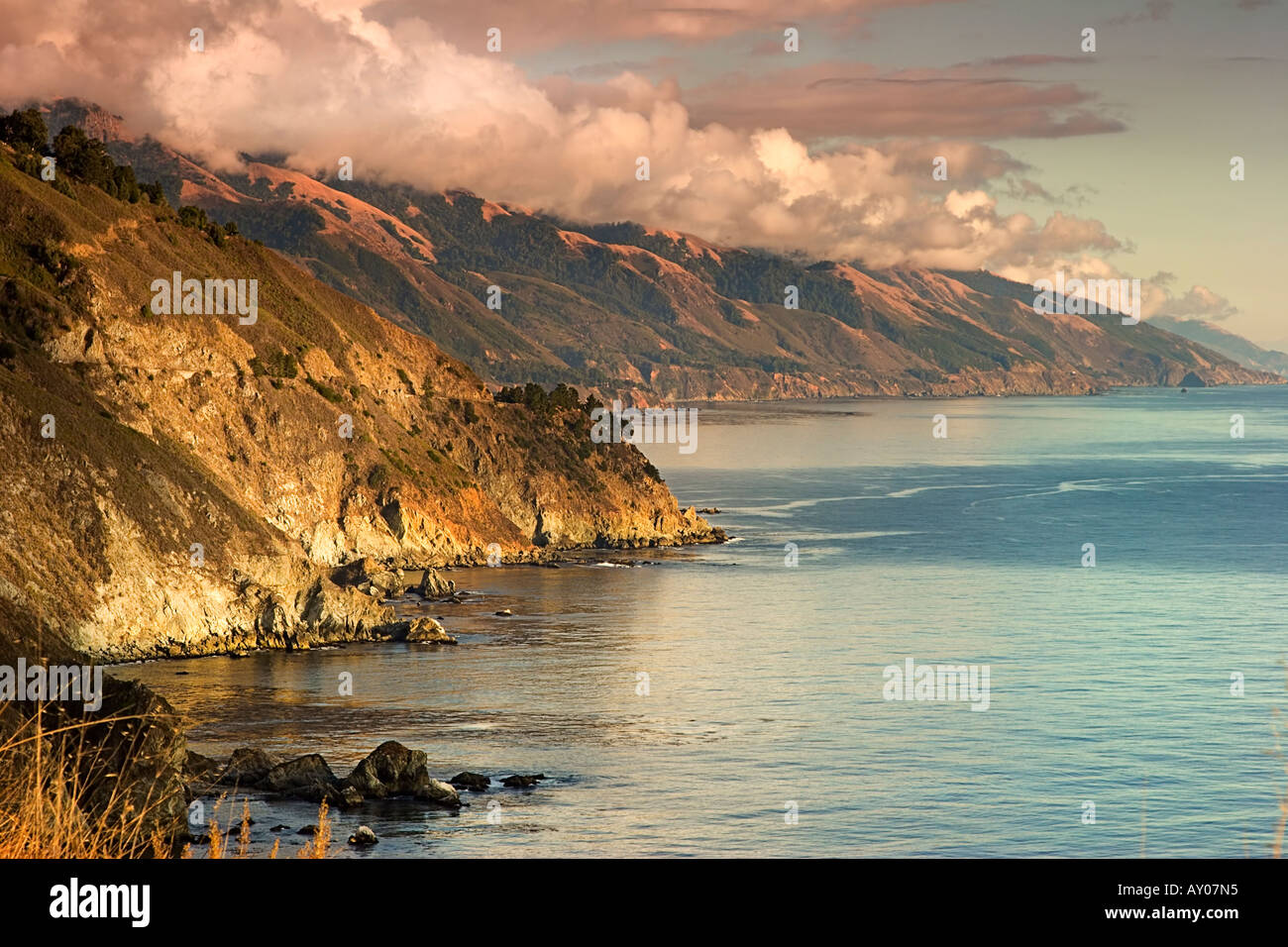 Setting sun reflects warm light over the central California coast at Grimes Point in Big Sur Stock Photo