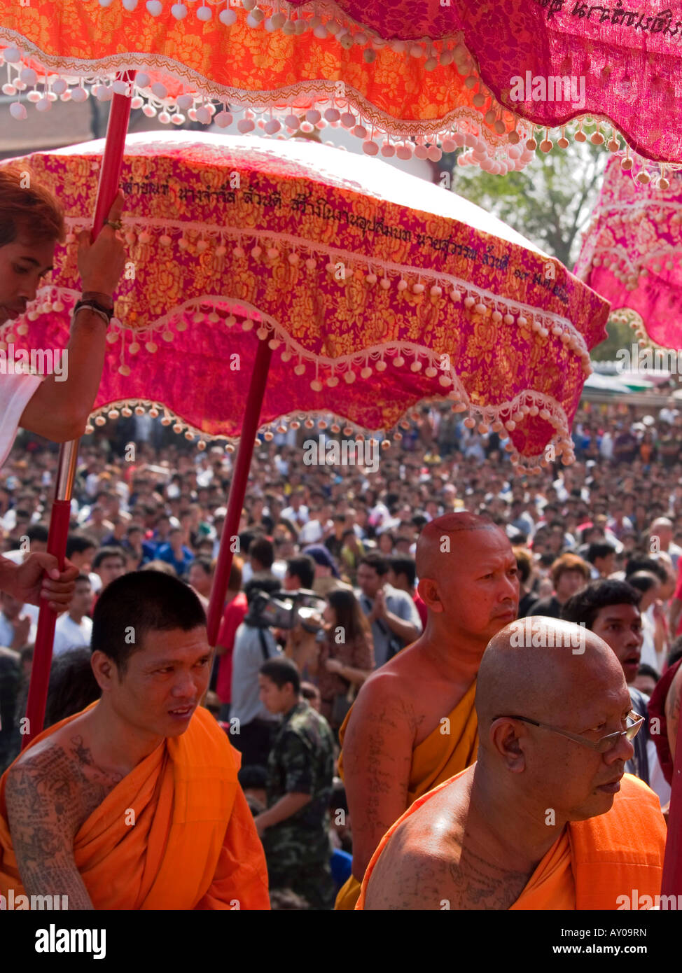 monks under umbrellas at the Wat Bang Phra Tattoo Festival in Thailand