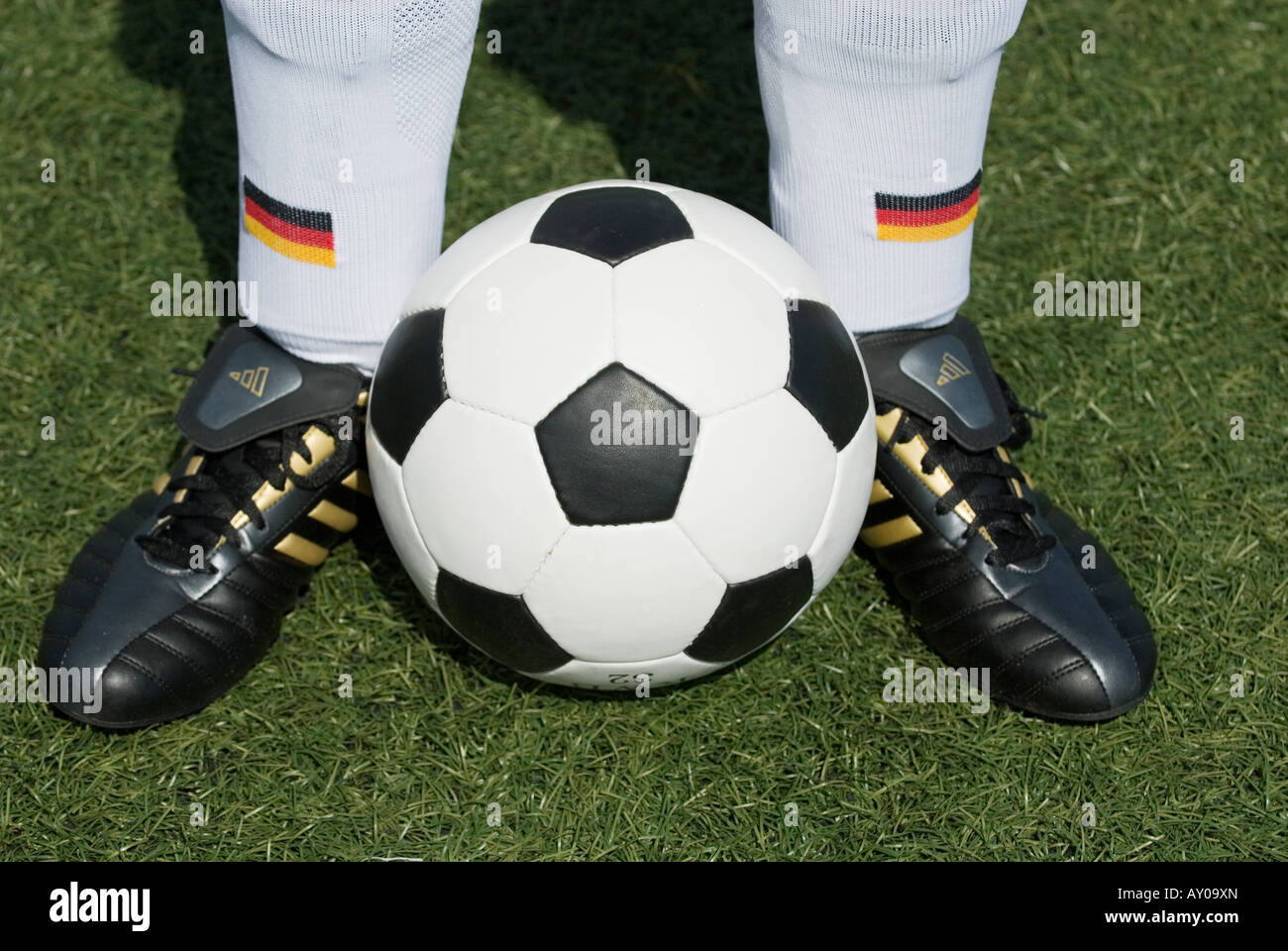 the feet of a german national football player and a vintage black and white football Stock Photo