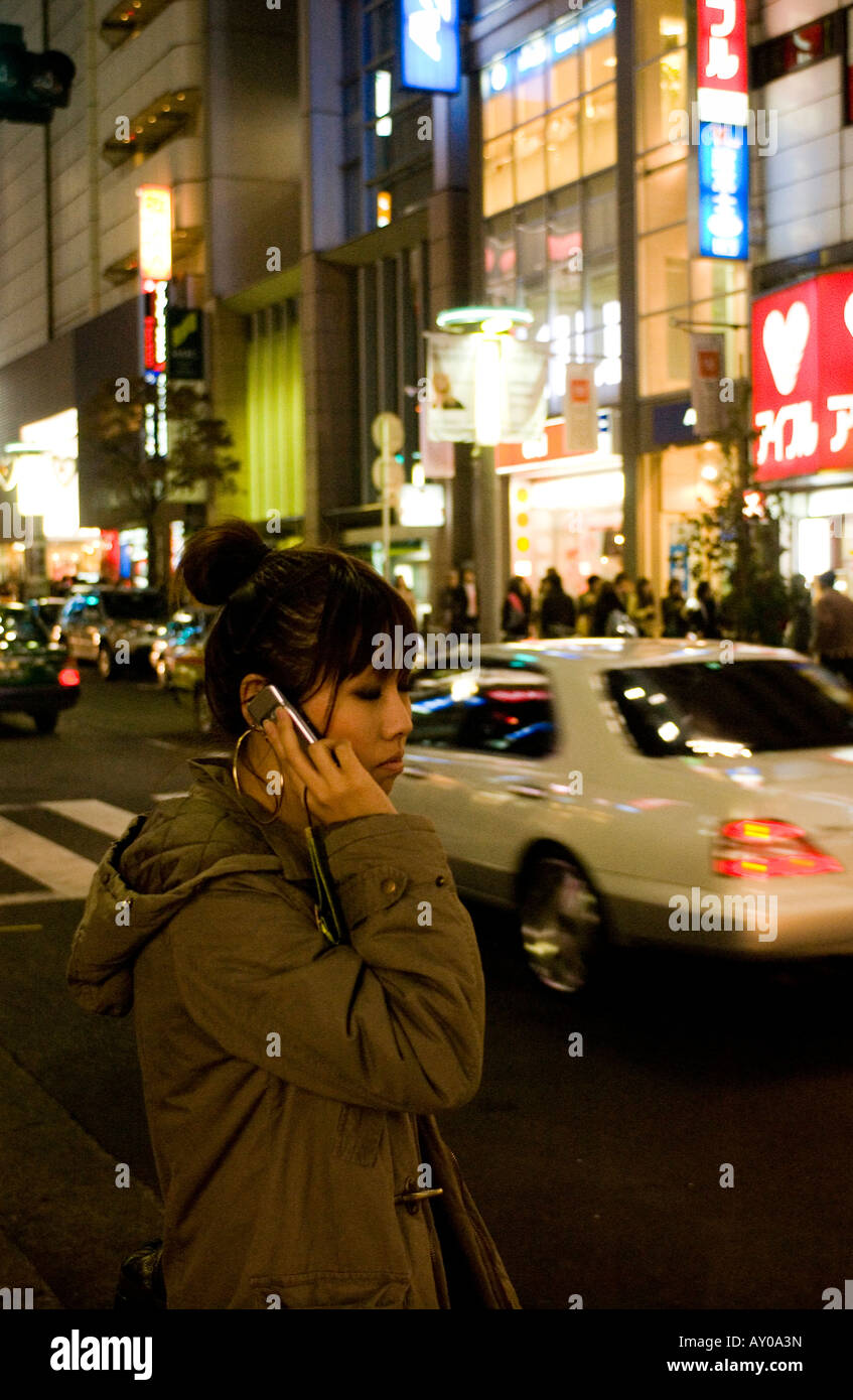 Woman waiting in a street on phone in Shibuya, Tokyo, Japan Stock Photo