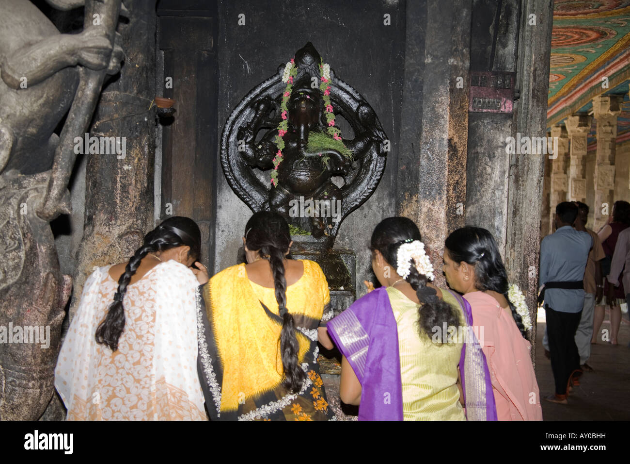 Female worshipers praying in front of a Ganesh shrine, Meenakshi Temple, Madurai, Tamil Nadu, India Stock Photo