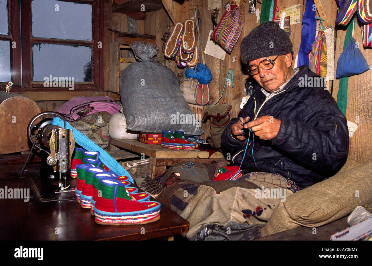 India Darjeeling West Bengal Tibetan Refugee man making traditional childs shoes Stock Photo