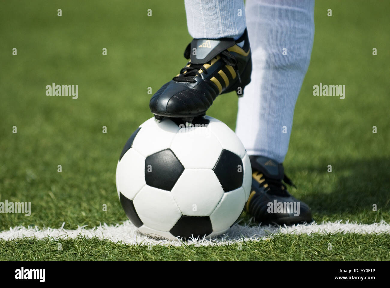 the feet of a football player in white stockings and a vintage black and white football Stock Photo