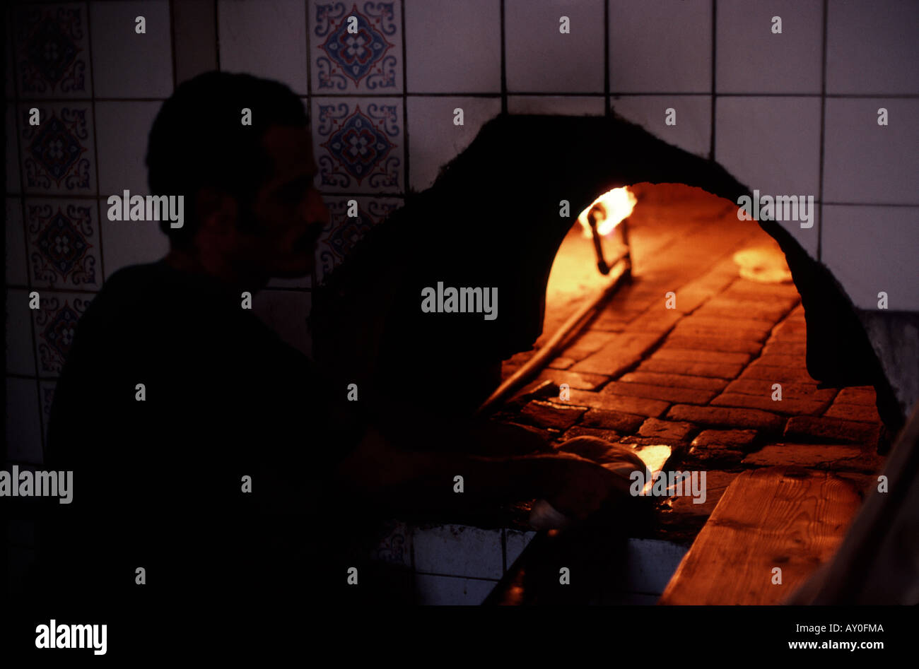 saudi baker making chapatis in open oven in souk in jeddah saudi arabia