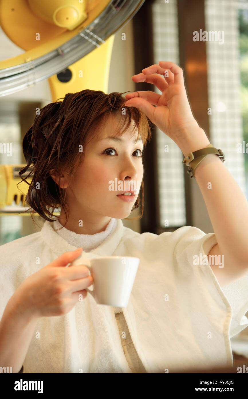 Young woman drinking coffee in hair salon Stock Photo Alamy
