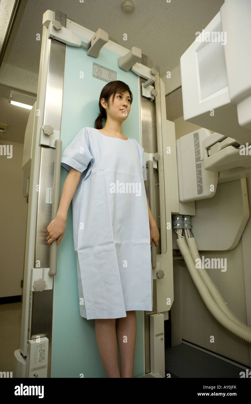 Young woman leaning against x-ray table Stock Photo
