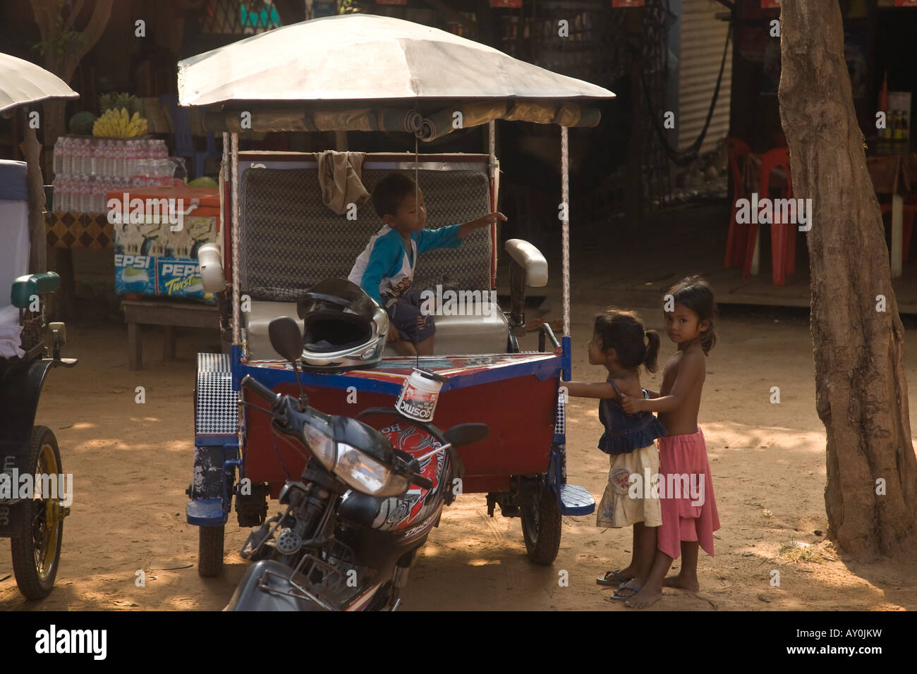3 children play in a rickshaw in Cambodia Stock Photo - Alamy