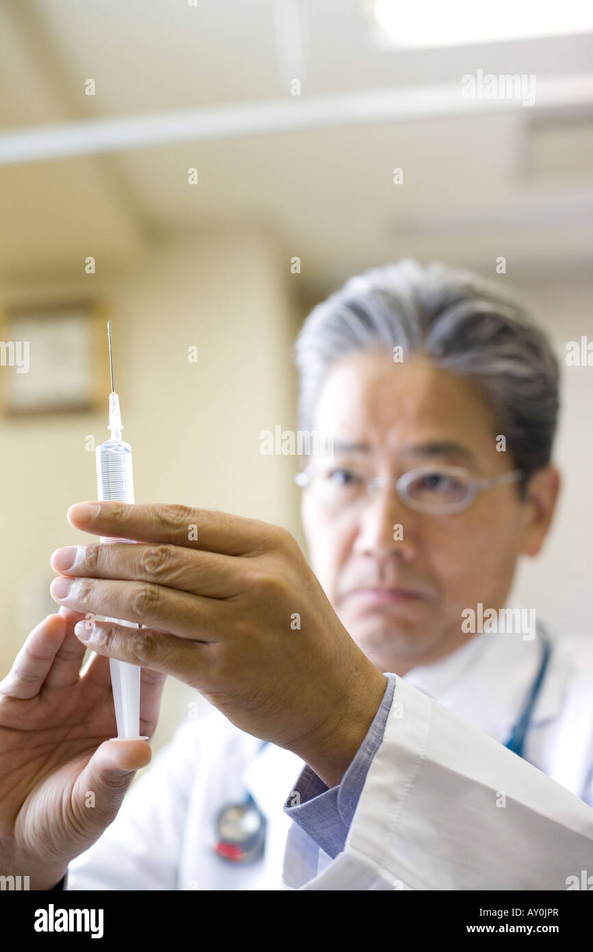 Doctor holding syringe Stock Photo