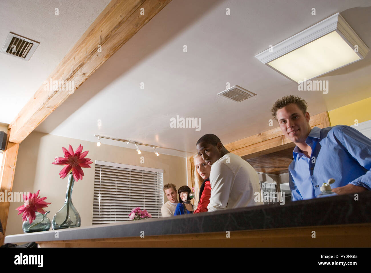 Portrait of men embracing women in domestic kitchen Stock Photo - Alamy