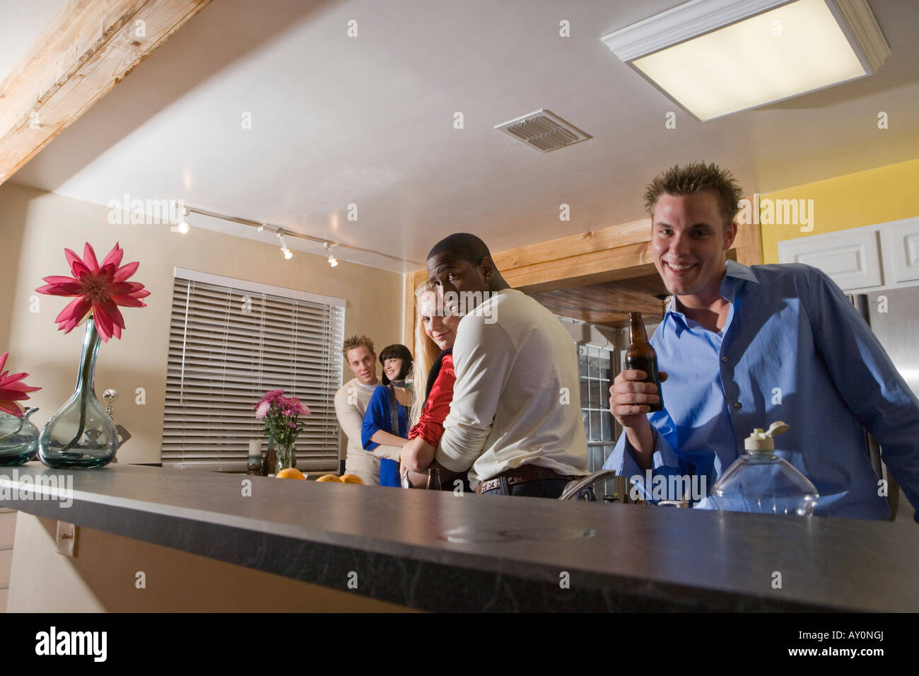 Portrait of men embracing women in domestic kitchen Stock Photo - Alamy