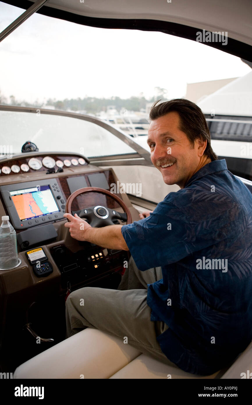 Portrait of a smiling young man steering boat Stock Photo - Alamy