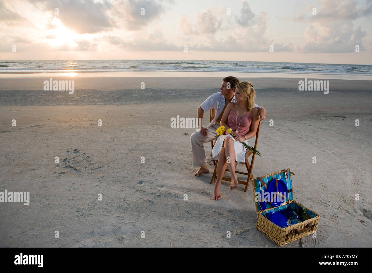Young couple relaxing on chairs at the beach Stock Photo - Alamy